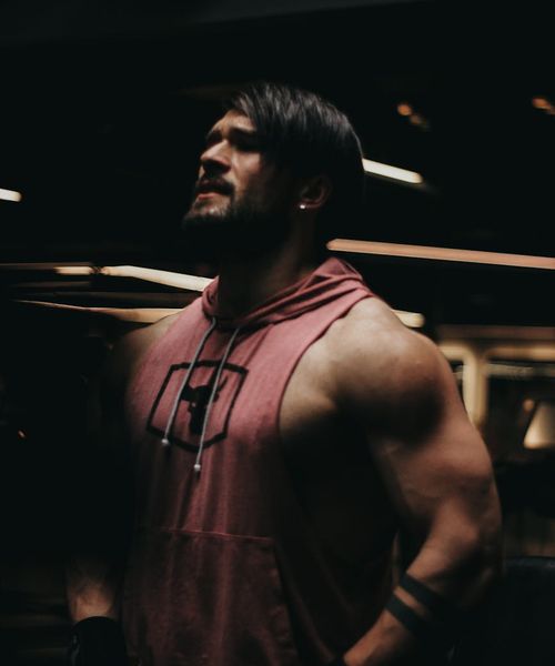 Man performing a core strength exercise in a dark gym.